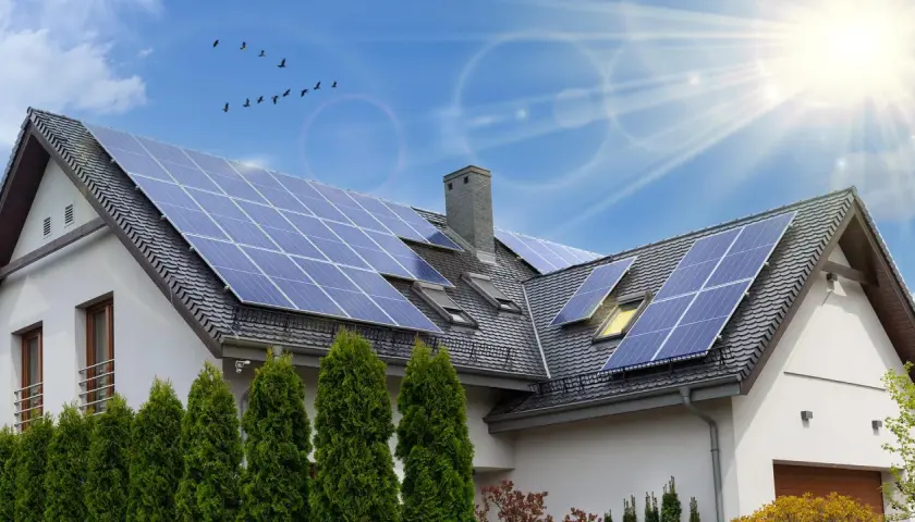 Instalacja fotowoltaiczna 6 kW cena z montażem na dachu domu. Słoneczny dzień, ptaki na niebie.
