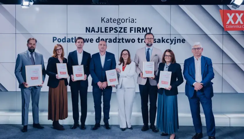 Grupa osób odbiera nagrody na tle ekranu z napisem "Kategoria: Najlepsze Firmy".