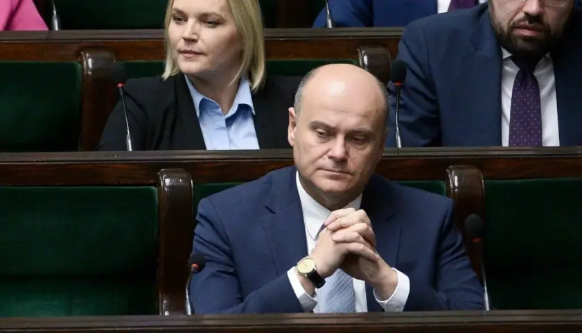 Poseł z zamyśloną miną, w garniturze, siedzi w ławach sejmowych. Czy to zapowiedź bankructwa Polski?