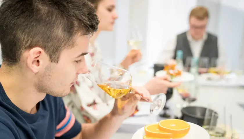 Teilnehmer einer WSET Kurse verkosten Wein und Orangen.