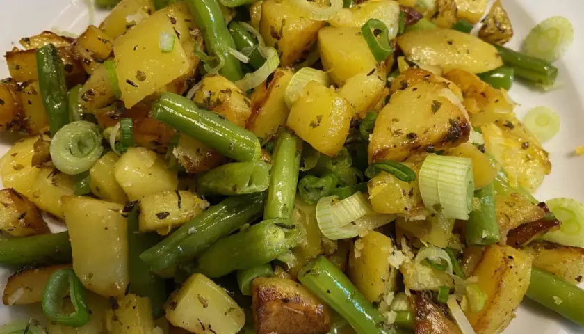 Herzhafte Kartoffel-Bohnen-Pfanne mit Frühlingszwiebeln, goldbraun gebraten und mit Kräutern verfeinert. Ein Genuss!