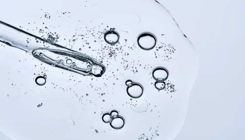 Kropla serum z pipetki, bąbelki unoszące się w żelu. Czy peptydy można łączyć z witaminą C? To pytanie nurtuje miłośników pielęgnacji.