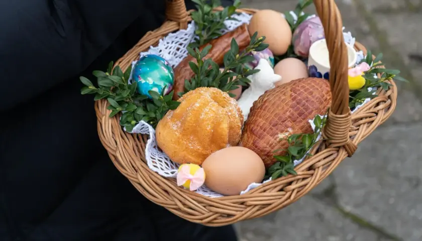 Wielkanocny koszyczek z jajkami, babką, kiełbasą i wędliną.