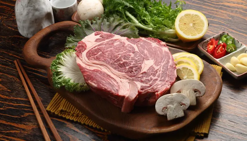 Rohes Rindersteak mit Pilzen, Zitrone und Kräutern. Wie lange kann man Rindfleisch einfrieren? Gut verpackt hält es Monate.