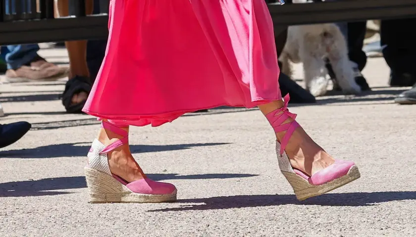 Pie de la Reina Letizia luciendo unas alpargatas de cuña rosas con cintas atadas al tobillo, combinadas con un vestido fucsia.