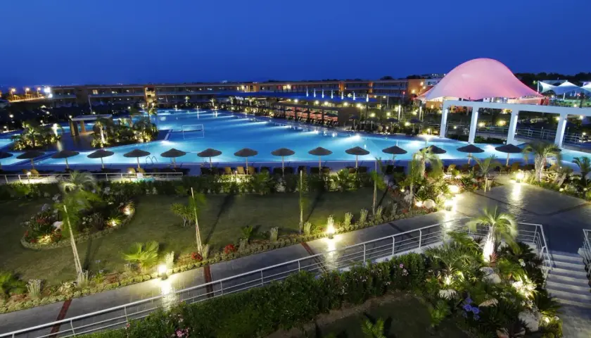 Piękny resort z basenem i palmami nocą. Wiele pozytywnych blue lagoon resort opinie potwierdza jego urok.