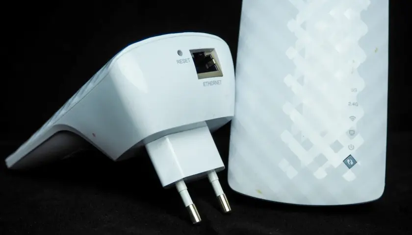 Dwa białe urządzenia sieciowe: wzmacniacz Wi-Fi z wtyczką i portem Ethernet oraz większy repeater z oznaczeniami 5G, 2.4G i ikonami.