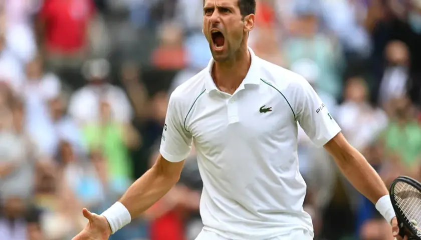 Emocjonalny tenisista Djokovic krzyczy z kortu, świętując zwycięstwo.