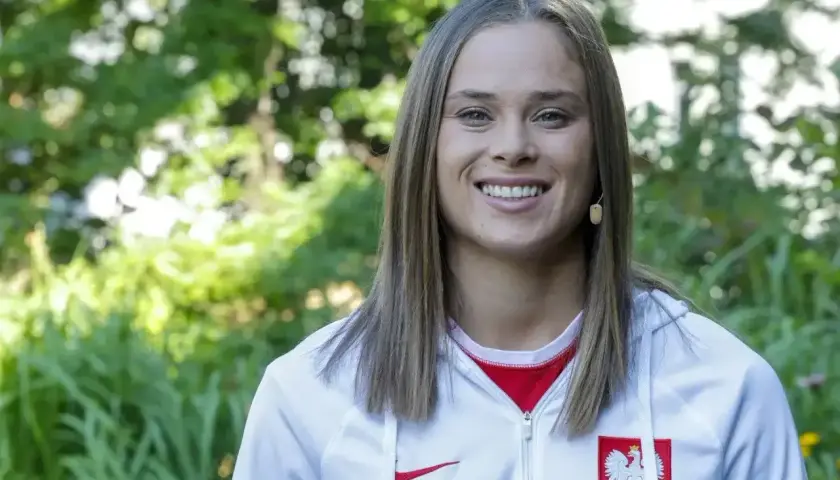 Uśmiechnięta Ewa Pajor w stroju reprezentacji Polski. Jej zarobki w klubie budzą zainteresowanie fanów.