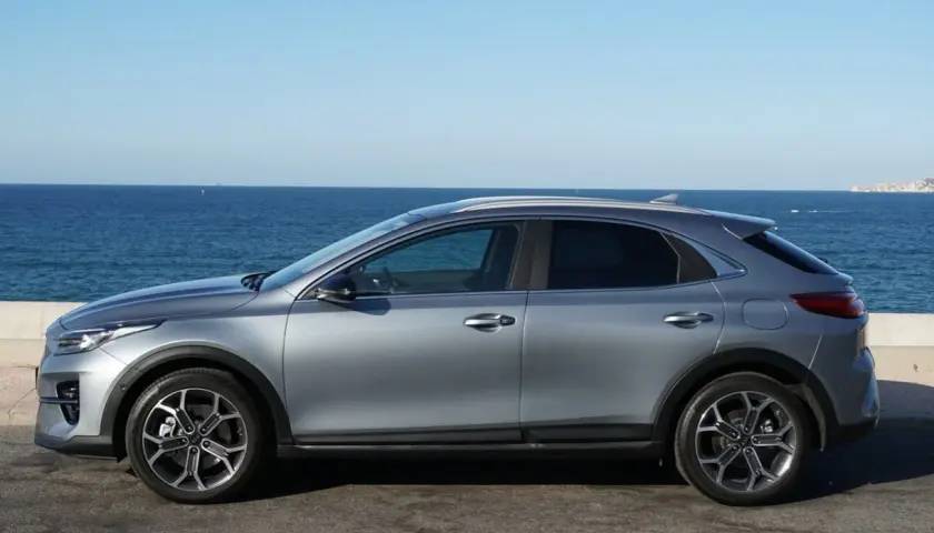 Un'auto grigia Euro 6 parcheggiata sul lungomare, con il mare blu e il cielo limpido sullo sfondo.