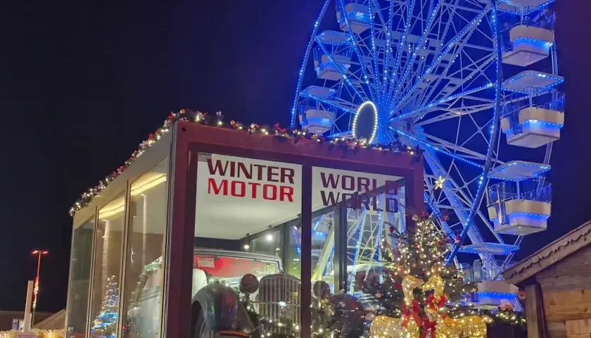 Ein glitzerndes Riesenrad und ein Oldtimer-Ausstellungsstück auf dem **Freimann Weihnachtsmarkt** versprechen winterliche Freude.