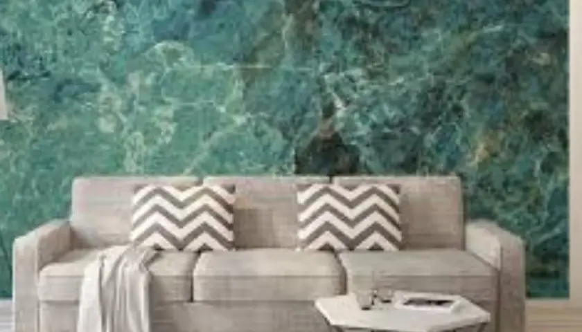 Soggiorno moderno con divano grigio e carta da parati su cartongesso effetto marmo verde acqua.