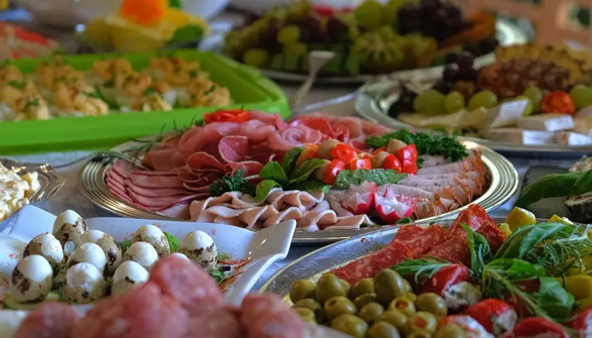 Bogaty catering imprezowy: wędliny, jajka przepiórcze, oliwki, warzywa i owoce. Idealne menu na przyjęcie.