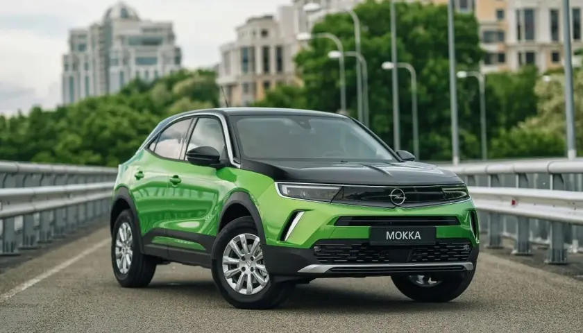 Zielony Opel Mokka na moście, z widocznymi felgami i oponami. Idealny rozmiar opon dla tego miejskiego SUV-a.