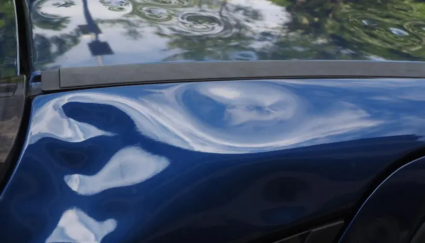 La mia auto blu parcheggiata è stata tamponata. Ci sono diverse ammaccature evidenti sulla carrozzeria, tra cui una grande e profonda. Ho la targa.