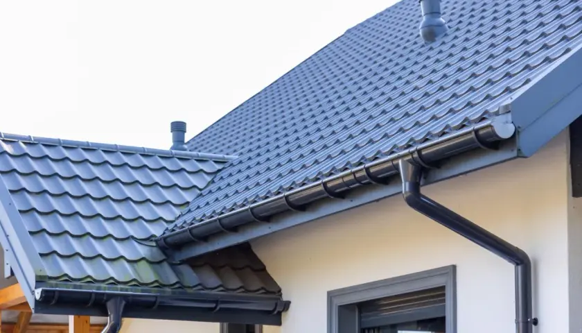 Szary dach z dachówki ceramicznej, idealny do obliczenia dachówka ceramiczna cena za m2. System rynnowy odprowadza wodę.