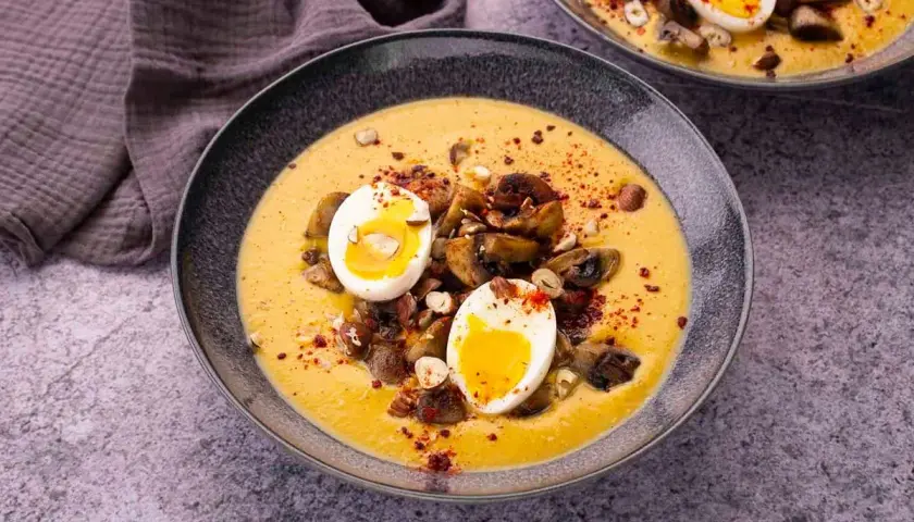 Velouté de patate douce garni de champignons, de noisettes et d'un œuf mollet.