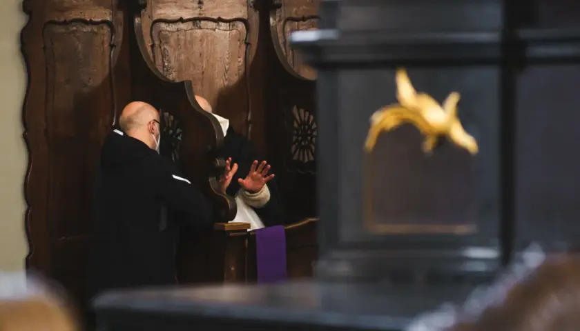 Spowiedź w konfesjonale. Mężczyzna w masce wyznaje swoje grzechy ciężkie, lista jest długa.