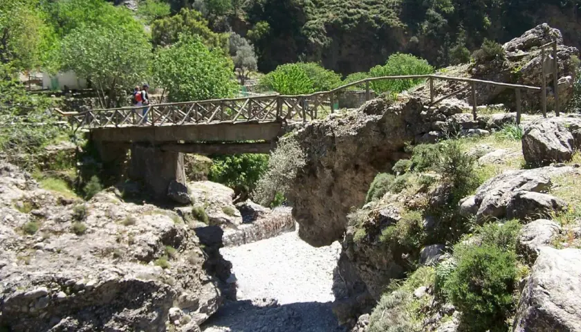 Holzbrücke überspannt die Samaria Schlucht, Wanderer überqueren sie.
