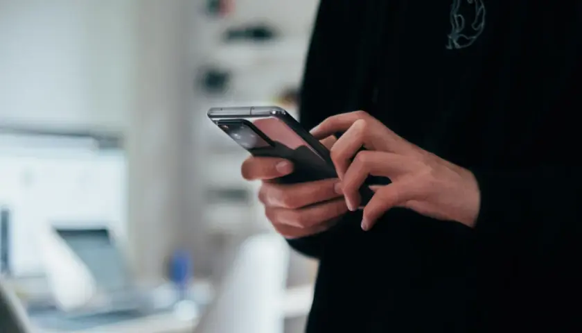 Dłonie trzymające nowoczesny smartfon, widok z bliska.