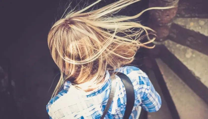 Rubia con pelo al viento, buscando cómo aclarar el pelo naturalmente.