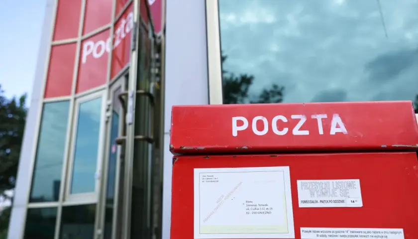 Czerwona skrzynka pocztowa z napisem "POCZTA". Obok niej informacja, ile listów poleconych czeka na poczcie do odbioru.