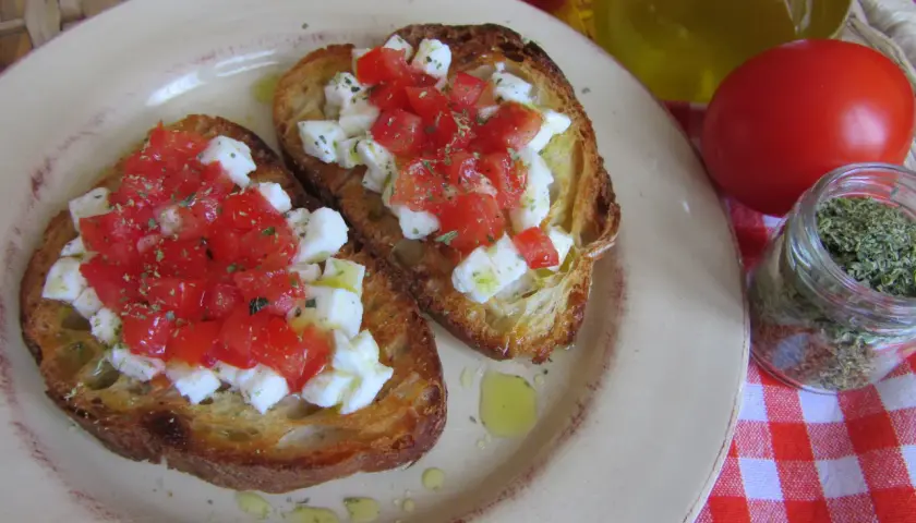 Bruschetta z pomidorami i mozzarellą: chrupiące grzanki z serem, pomidorami i ziołami. Idealny przepis na szybką przekąskę.