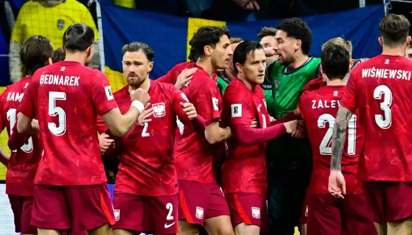 Piłkarze w czerwonych strojach z orzełkiem na piersiach, świętujący sukces. Polska drużyna walczy o mistrzostwa świata.
