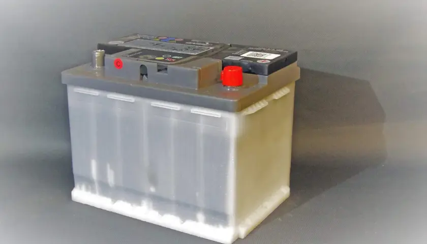 Autobatterie auf grauem Hintergrund. Beachten Sie die Lagerung von Autobatterien Vorschriften für sicheren Umgang.