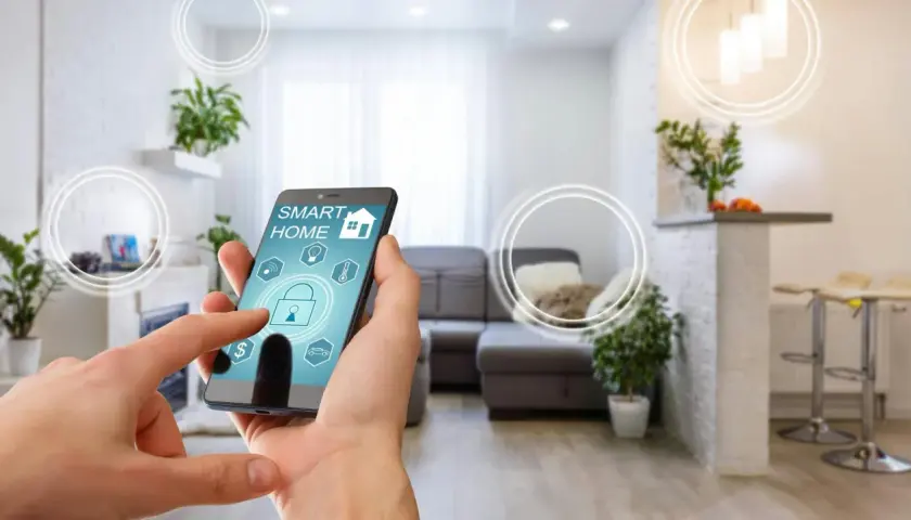 Smart home od czego zacząć? Telefon z aplikacją sterującą domem w nowoczesnym salonie.