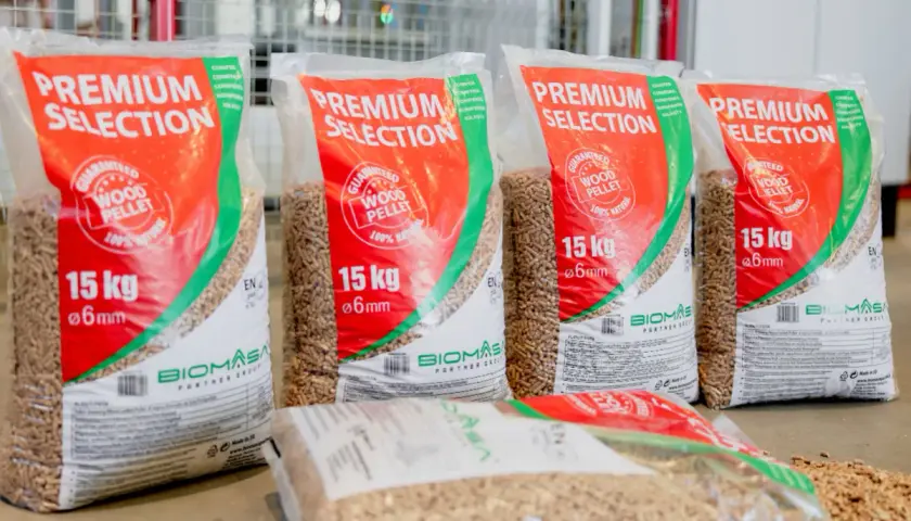 Kilka worków z napisem "PREMIUM SELECTION" zawierających pellet drzewny premium. Każdy worek waży 15 kg i zawiera pellet o średnicy 6 mm.