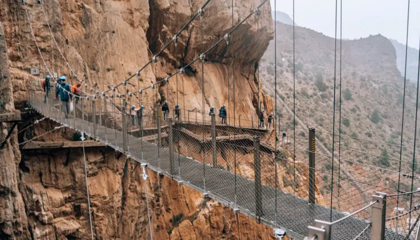 Spacer po Caminito del Rey z dzieckiem. Wąska ścieżka zawieszona nad przepaścią, otoczona skalnymi ścianami.