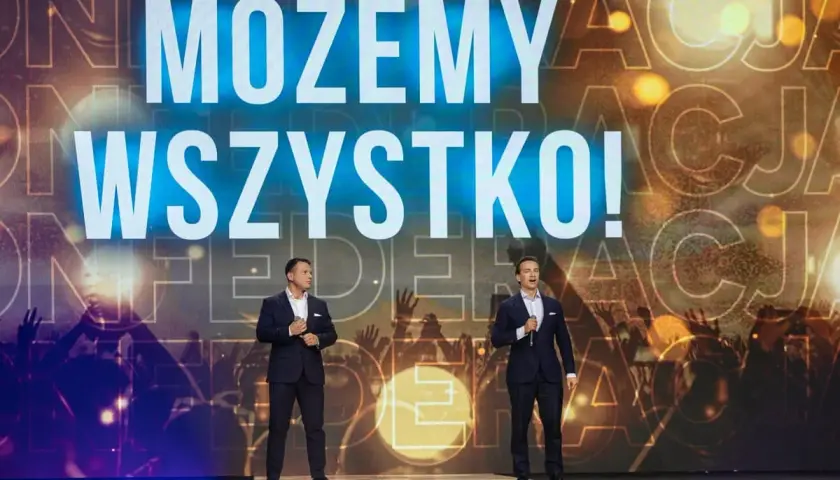 Dwóch mężczyzn na scenie, za nimi napis "MOŻEMY WSZYSTKO!". Konfederacja chce wprowadzenia bonu oświatowego od września 2026.