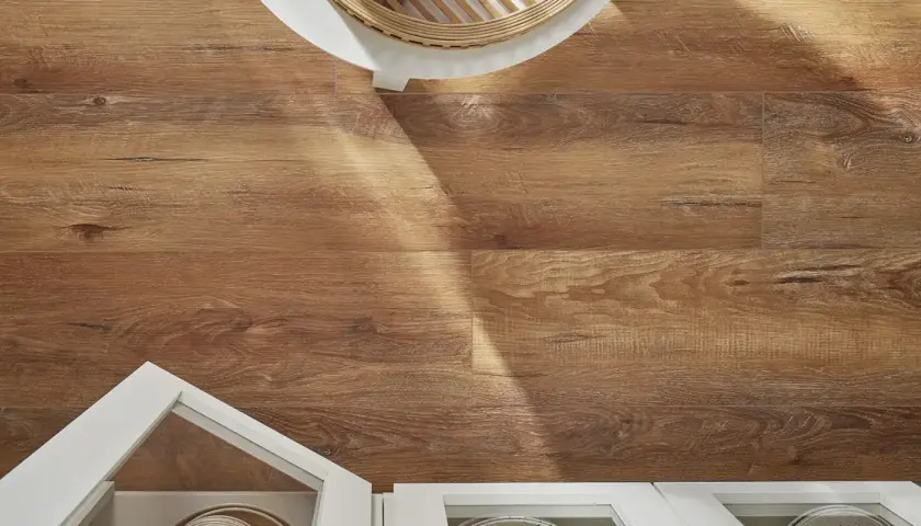Drewnopodobne panele laminowane czy winylowe tworzą ciepłą podłogę. Białe meble i kosz dodają stylu.