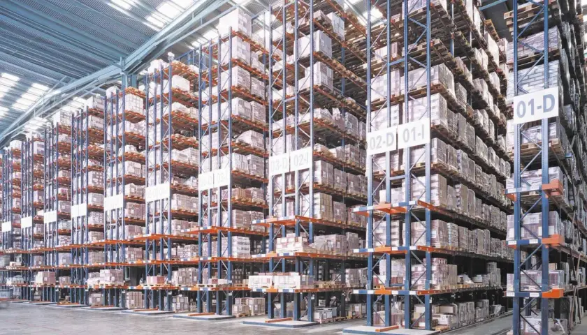 Hohe Regale in einem Lagerhaus, gefüllt mit Kisten und Paletten. Effiziente Regalarten Logistik für maximale Lagerkapazität.