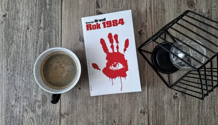 Kawa i książka "Rok 1984" George'a Orwella. Biografia autora w tle.