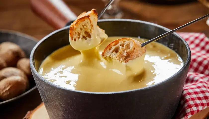 Des morceaux de pain trempés dans une fondue au fromage crémeuse. Un délice de pain fondue à partager.