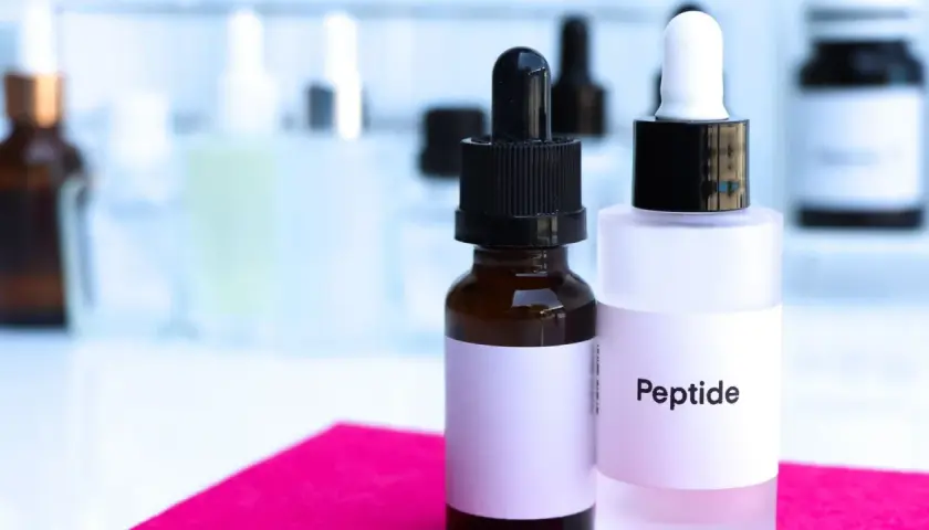 Dwie buteleczki z pipetkami, jedna z napisem "Peptide". Pamiętaj, z czym nie łączyć peptydów miedziowych, by uniknąć podrażnień.