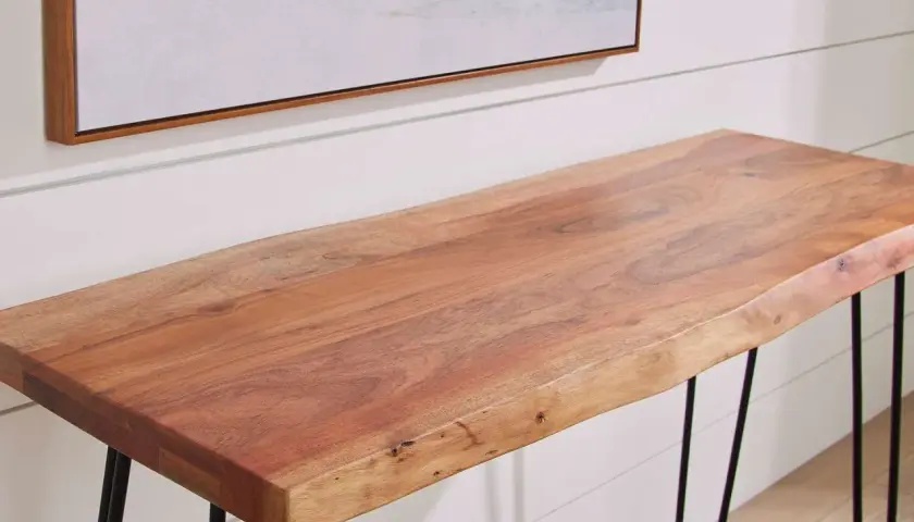 A live-edge acacia wood console table with black hairpin legs, showcasing the natural grain and warmth of the wood.