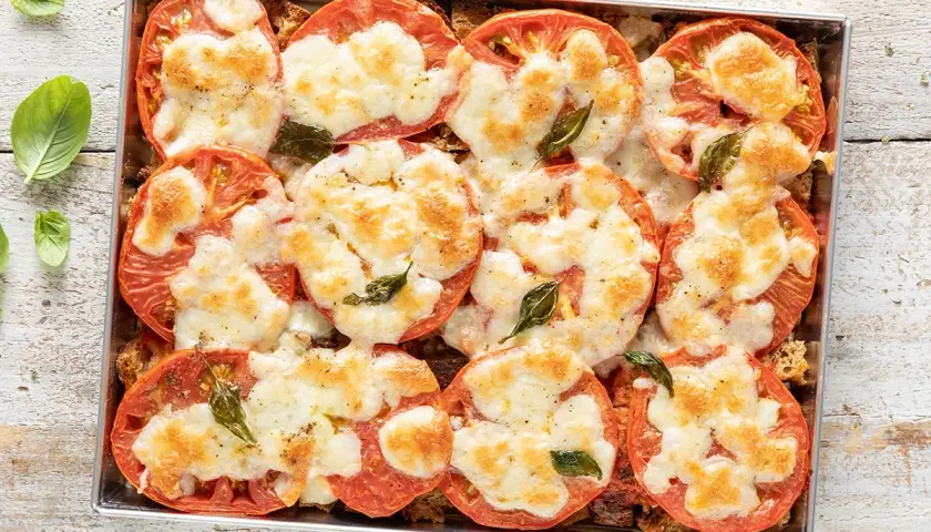 Pomodori al forno con mozzarella filante e basilico. Un'idea gustosa per cosa mangiare stasera, semplice e veloce da preparare.
