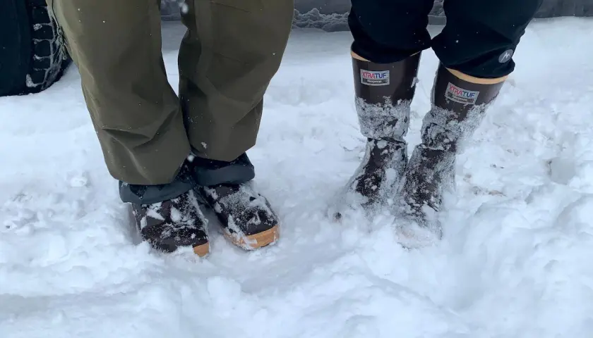 Two pairs of winter boots in snow. The Xtratuf boots fit snugly, allowing for thick socks.