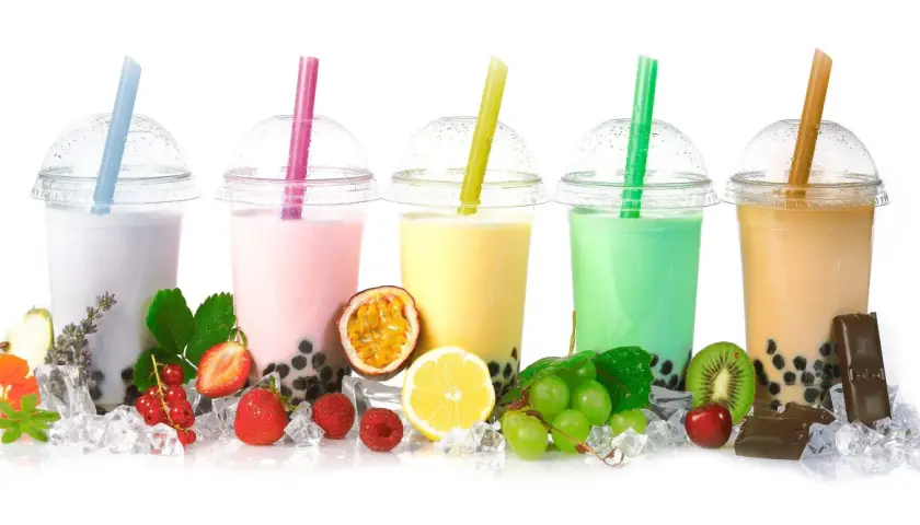 Pięć kolorowych bubble tea z owocami, lodem i słodyczami.