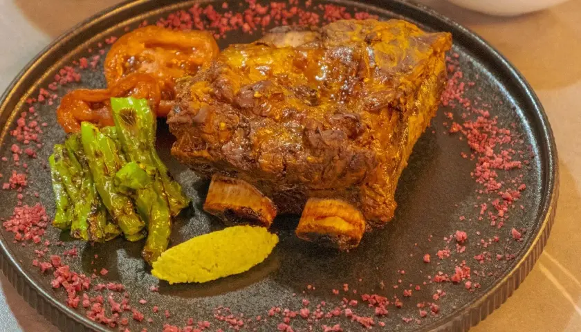 Soczysta żeberka w marynacie musztardowo miodowej na grilla, podane z pieczonymi pomidorami, papryczkami i zielonym puree.
