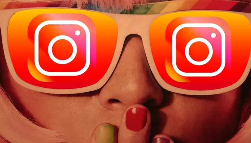 Osoba z kolorowymi włosami i paznokciami, w okularach z logo Instagram. Chcesz wiedzieć, jak zrobić podsumowanie roku na Instagramie?