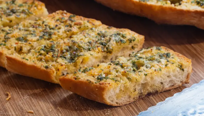 Knoblauchbrot selbst machen ist einfach! Hier sind knusprige Scheiben Baguette mit Butter, Knoblauch und Kräutern belegt, bereit zum Genießen.