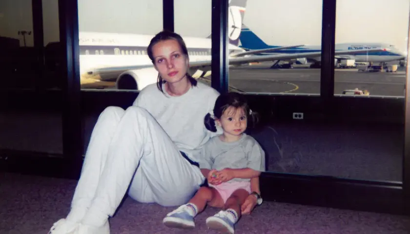 Agnieszka Kotlarska z córką na lotnisku, w tle samoloty British Airways i El Al.