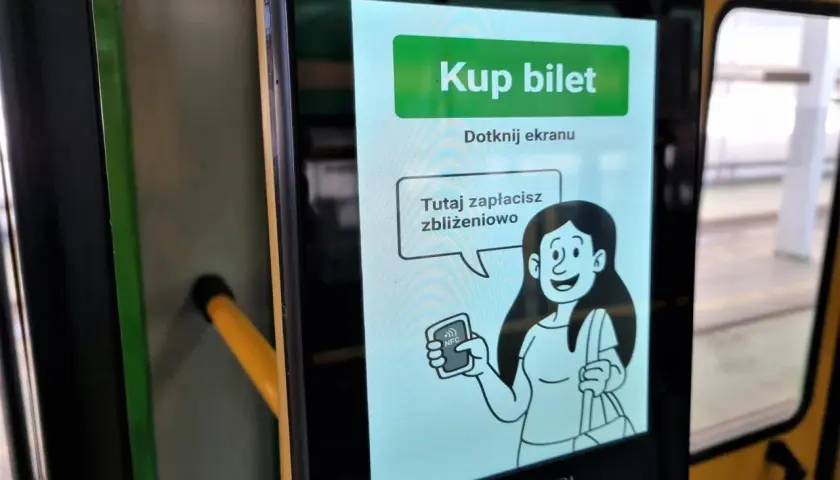Ekran automatu MPK z napisem "Kup bilet". Można tu zapłacić zbliżeniowo, co pokazuje grafika kobiety z kartą NFC.