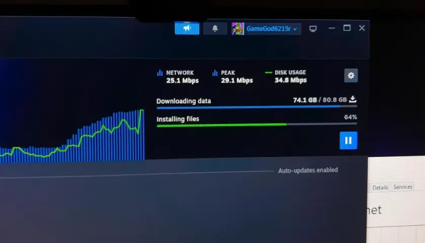 Monitorowanie pobierania na Steam, aby sprawdzić, jak przyśpieszyć pobieranie. Widoczny wykres sieci i postęp instalacji.