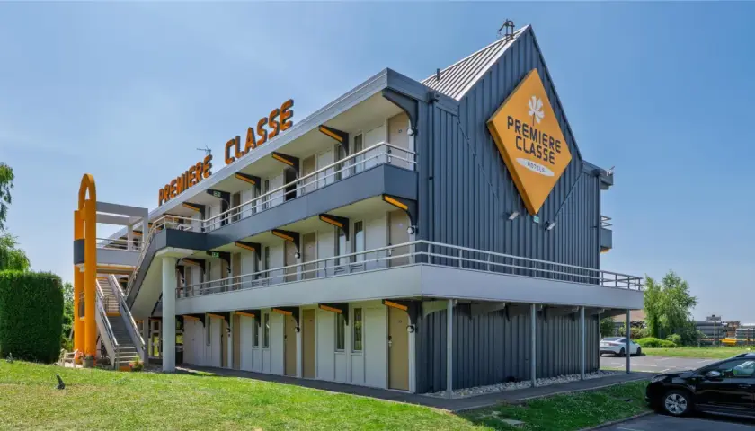 Façade d'un hôtel Première Classe avec escalier extérieur et parking.