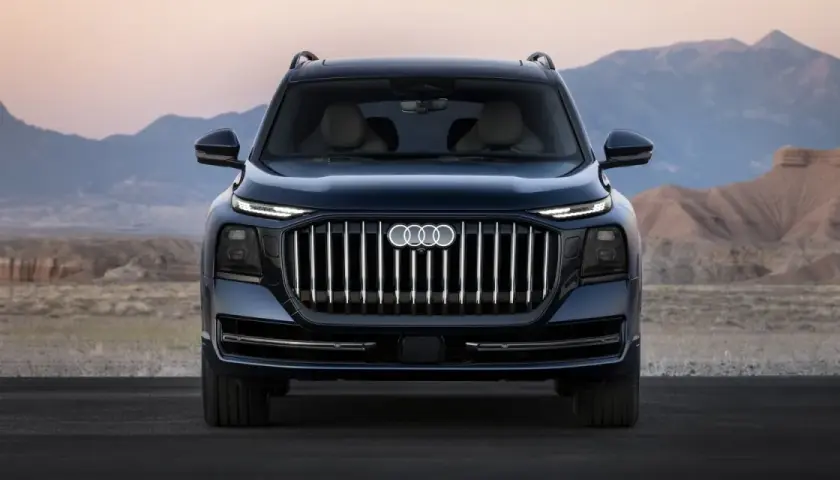 L'imponente Audi Q9 si staglia su uno sfondo desertico, con la sua griglia audace e i fari affilati che catturano lo sguardo.